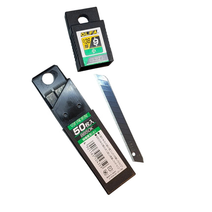 Two utility knives on a cutting mat with visible brand labels.