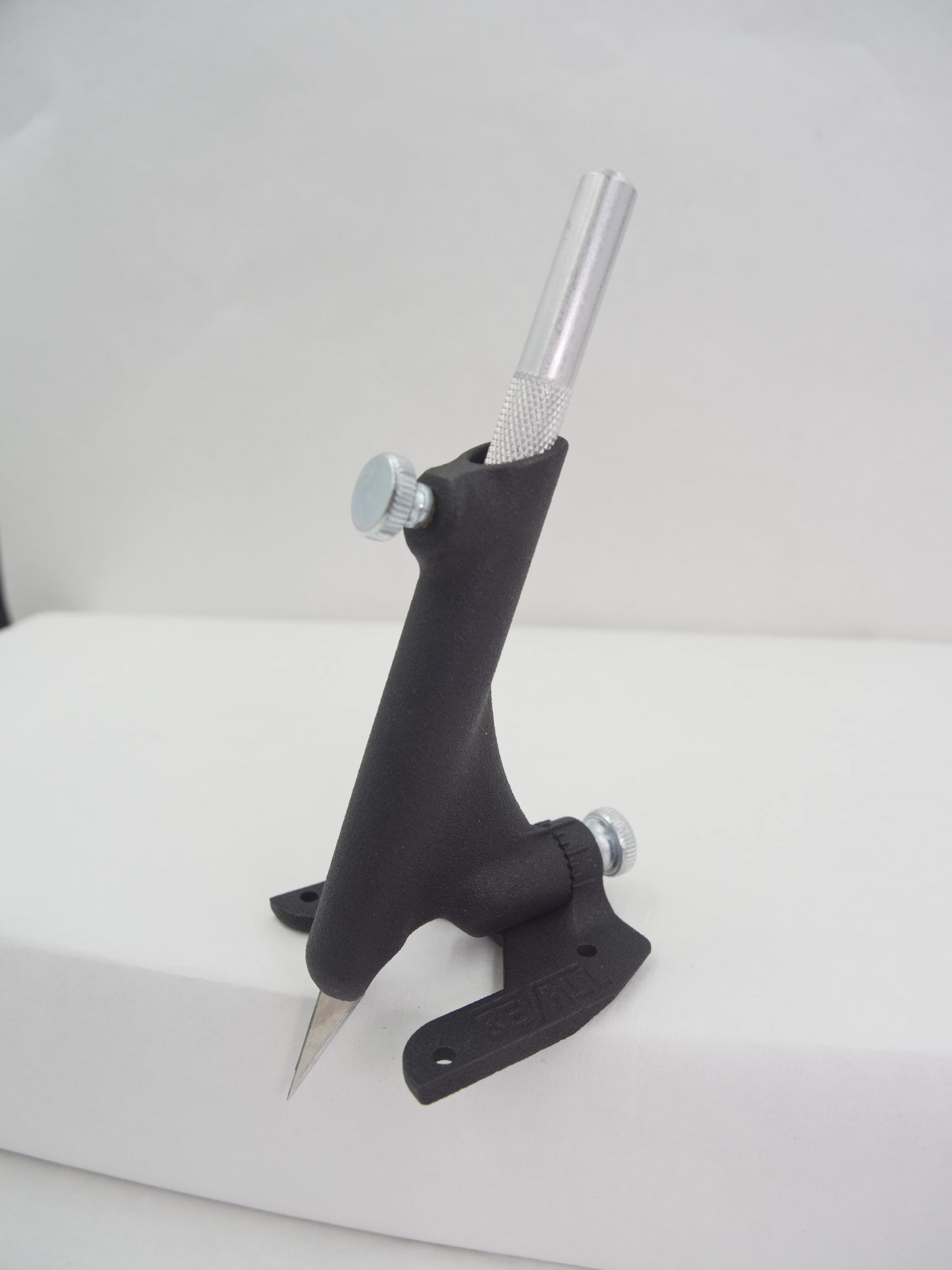 Black metal tool with a cylindrical handle on a white background