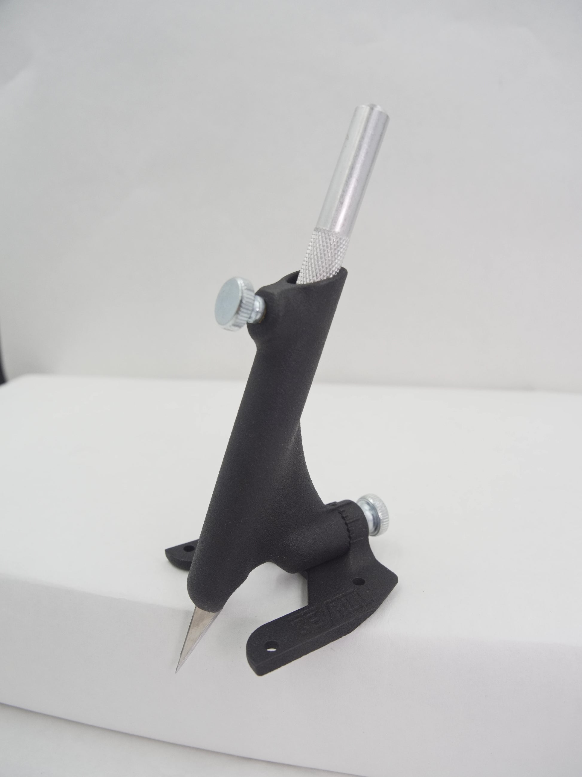 Black metal tool with a cylindrical handle on a white background