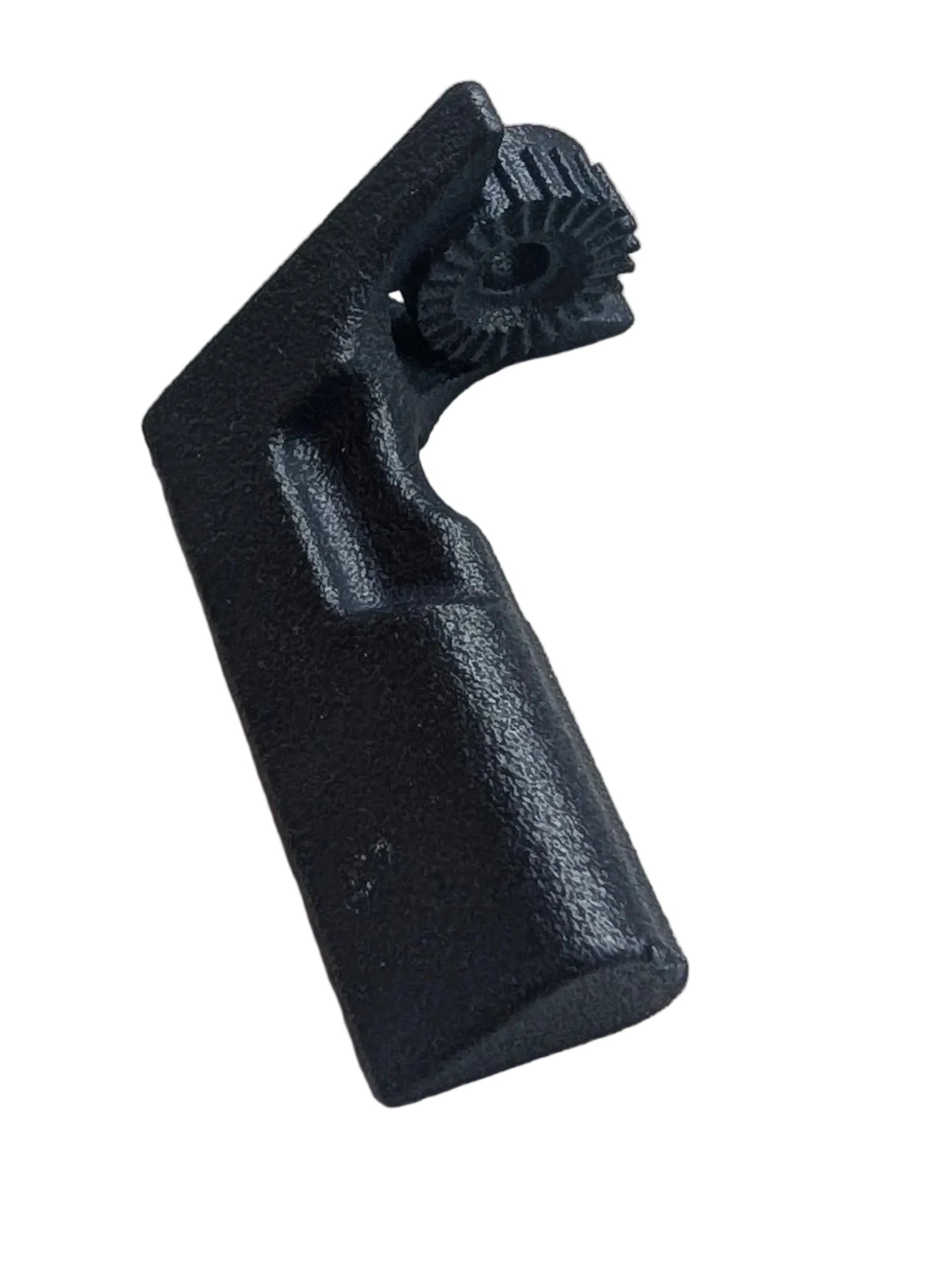 A small black molded plastic component with a textured, ribbed top surface, resting on a piece of white foam over a green cutting mat.